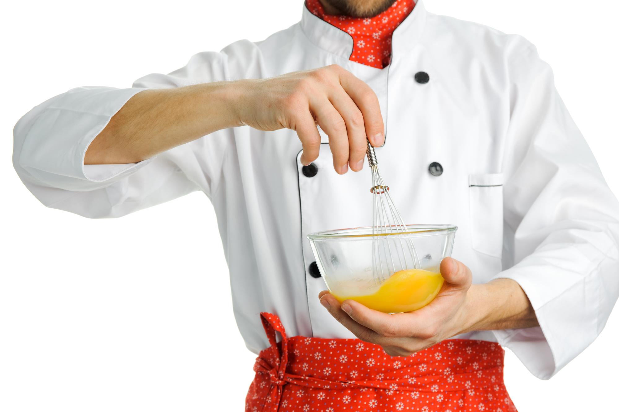 Chef demonstrating plating technique in compact studio kitchen